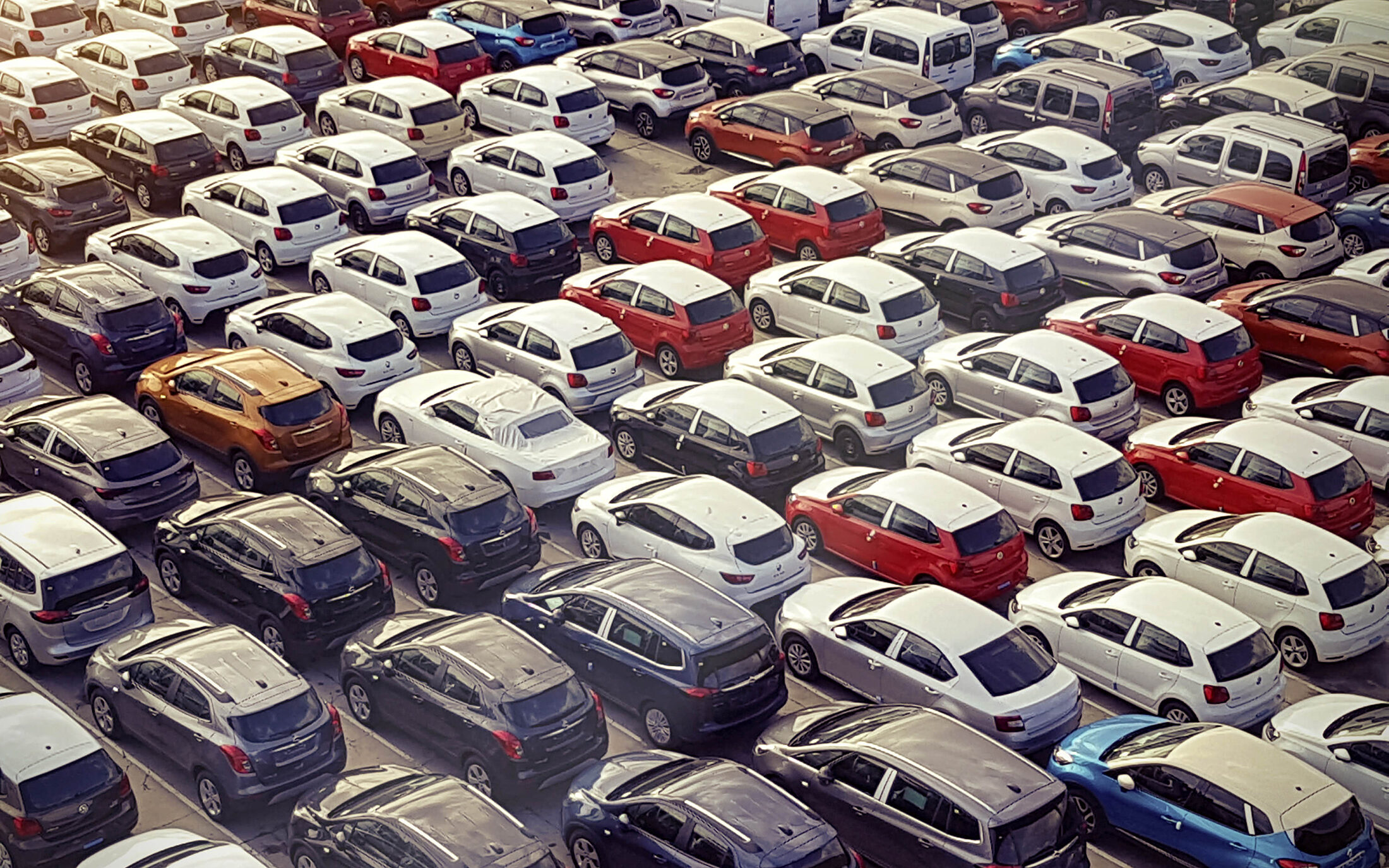 Lot full of many different types and colours of cars